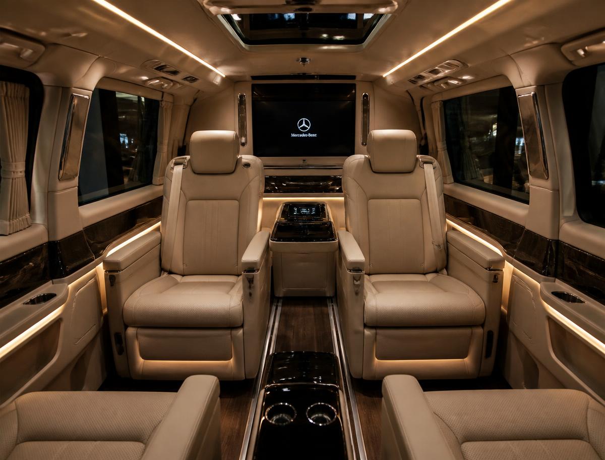 Mercedes-Benz V-Class interior with beige leather captain chairs and ambient lighting